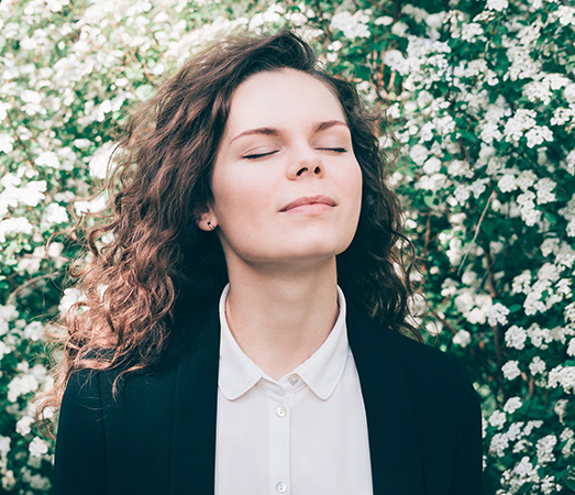 Woman taking deep breaths and feeling sunlight on her face